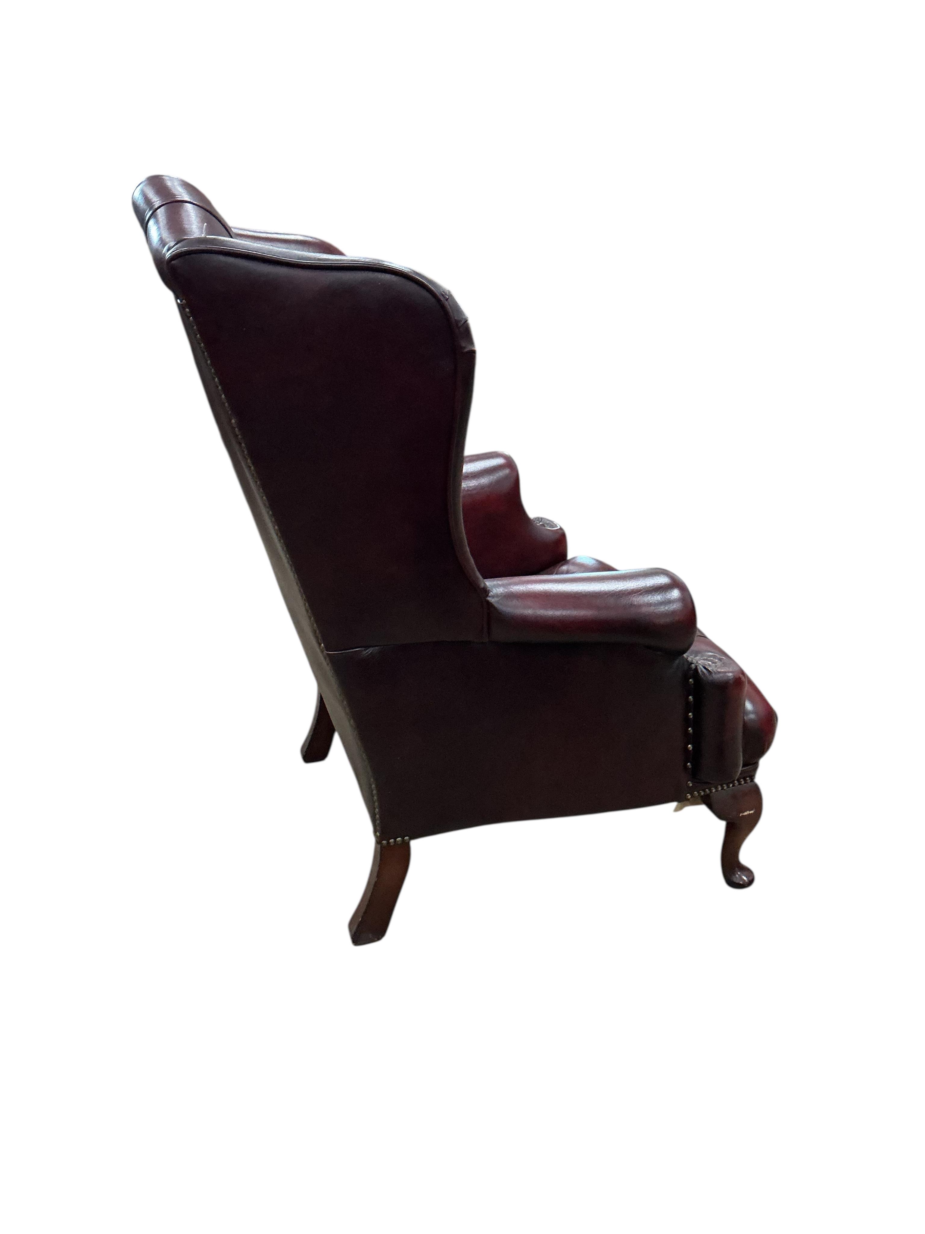 A pair of reproduction buttoned burgundy leather wing armchairs, width 82cm, depth 70cm, height 104cm